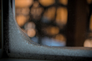 abstract close-up of condensation and ice on the interior edge of a window pane interior building architecture cold winter surface texture bokeh light background