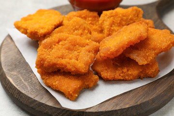 Delicious chicken nuggets on grey table, closeup