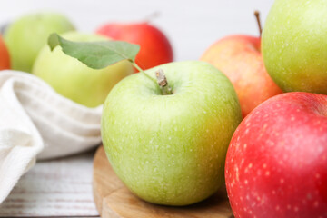Different whole ripe apples on wooden table, closeup
