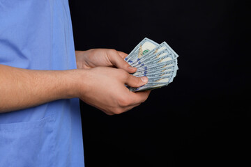 Corruption concept. Doctor with dollar banknotes on black background, closeup