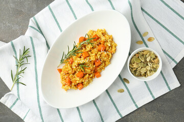 Delicious pumpkin risotto with rosemary on grey table, flat lay