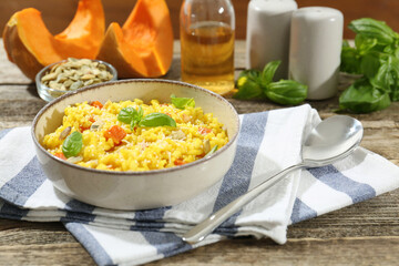 Delicious pumpkin risotto served on wooden table, closeup