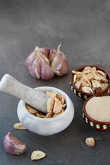 Dried garlic. Pieces of dried garlic are crushed in a mortar