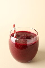 Fresh beetroot smoothie in glass on beige background, closeup