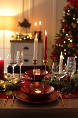 Christmas place setting with festive decor on wooden table in room