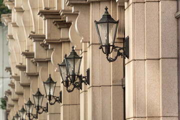 A photo of an ornate building wall with lamps.