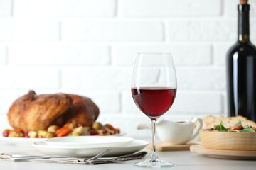 Red wine and delicious dinner served on light table
