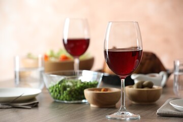 Red wine and delicious dinner served on wooden table