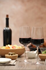 Red wine and delicious dinner served on wooden table