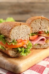 Delicious sandwiches with ham on wooden table, closeup