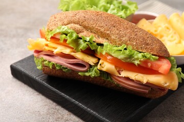 Delicious baguette sandwich with ham on grey table, closeup