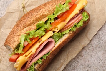 Delicious baguette sandwich on grey table, top view