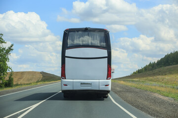 tourist bus moves along a country road