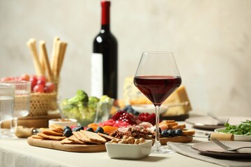 Red wine and different snacks served on table