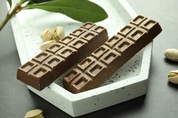 Tasty Dubai chocolate with pistachios and knafeh on grey textured table, closeup