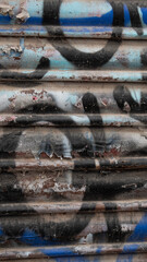 Rusty old shutter with graffiti