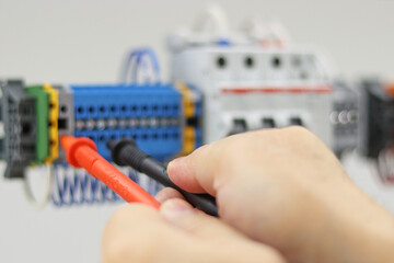 Measurement of electrical parameters in a switchboard using a multimeter.