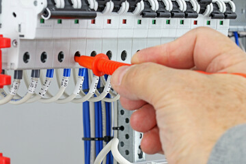 Measurement of electrical parameters in a switchboard using a multimeter.