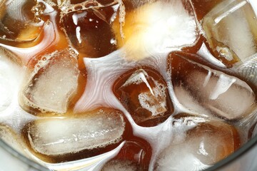 Refreshing coffee with ice and milk in glass, top view