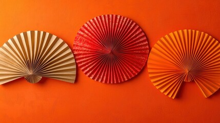 Paper fans on orange background, decorative backdrop.
