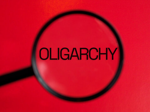 OLIGARCHY text through magnifying glass red background
