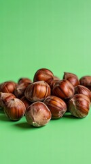 Close up of a Pile of Hazelnuts on a Green Background