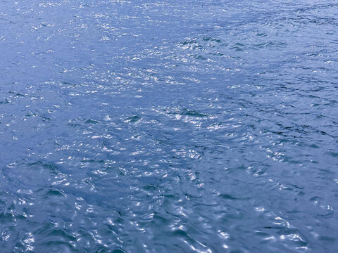 Blue ocean water glittering surface aqua background 