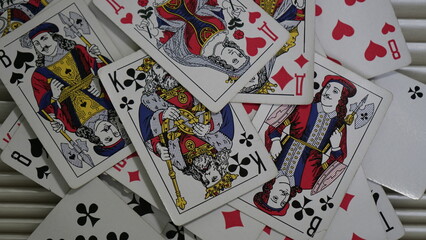 Deck of playing cards scattered artfully on a textured surface, showcasing royal figures and suits in vibrant colors during a cozy game night