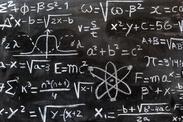 Operaciones y formulas matemáticas y de física cuántica escritas con una tiza en la pizarra	