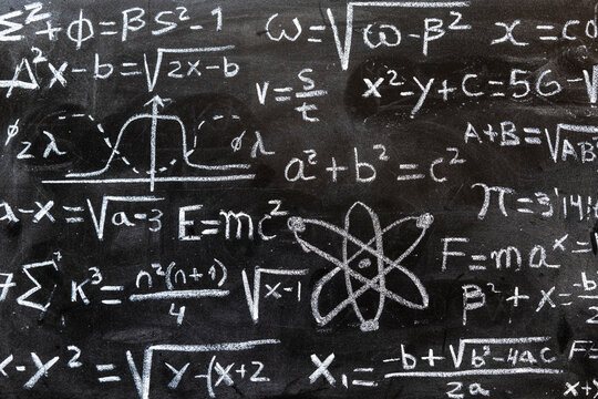 Operaciones y formulas matemáticas y de física cuántica escritas con una tiza en la pizarra	