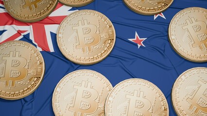 Several bitcoins are laid out on the flag of New Zealand