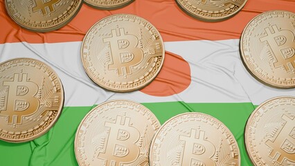 Several bitcoins are laid out on the flag of Niger