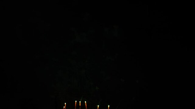 Silver red pink sparks scattering fireworks on the black night sky. General plan