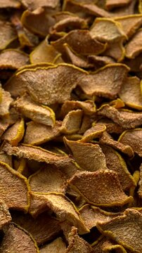 Dried quince slices background texture. Table spin. Vertical video.