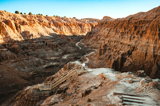 Woman is hiking down a staircase into a canyon at Cathedral Gorge State Park, Panaca, Lincoln County, Nevada, USA