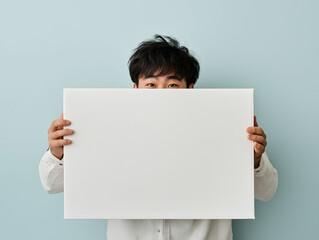 an asian happy young man hugging a huge white box and looking down at the box
