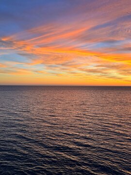 Dusk sky clouds over calm sea.
