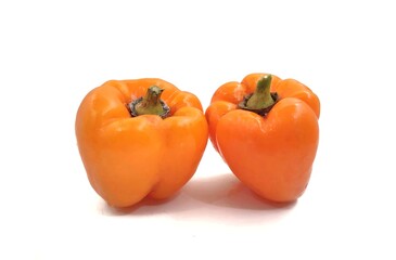 Photo of two orange bell peppers (California wonder), isolated on white background.