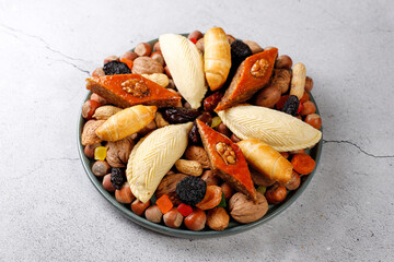 Traditional Azerbaijan holiday Novruz background with green semeni,traditional azerbaijan sweets,shekerbura,qogal,paxlava,mutaki and different nuts and sweets,top view,space for copy