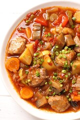 Delicious stew with vegetables in bowl on table, top view