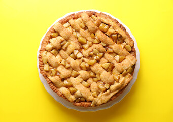 Tasty homemade apple pie on yellow background, top view