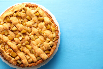 Tasty homemade apple pie on light blue wooden table, top view. Space for text