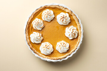 Tasty homemade pumpkin pie in baking dish on beige table, top view