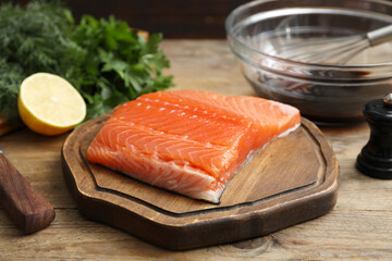 Salmon fillet and other products on wooden table, closeup