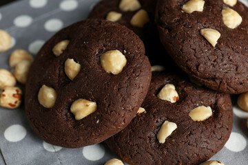 Delicious chocolate cookies with hazelnuts on table, closeup