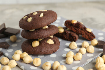 Tasty chocolate cookies with hazelnuts on table, closeup