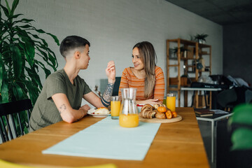 Lesbian couple enjoying breakfast and talking at home