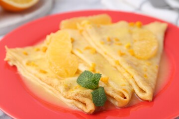 Plate with tasty crepes Suzette on table, closeup