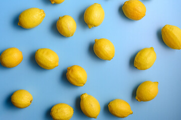 Top view of yellow lemons on blue background.