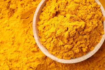 Turmeric powder in bowl on spice, top view